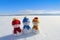 Friends snowman in red, blue, yellow hats and scarfs. Nice winter scenery with mountains, forest, field in snow.