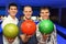 Friends stand alongside and hold balls for bowling