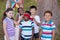 Friends standing around blindfolded boy at campsite