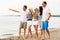 Friends in striped clothes walking along beach