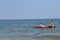 Friends swim together in the sea with a water mattress