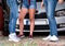 Friends talking in front of a parked car