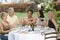 Friends Toasting Drinks At Dinner Table In Garden