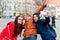 Friends in a touristic city center, taking a selfie.