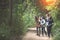 Friends or tourists with colorful backpacks in forest. Summer vacation. Travelling, hiking