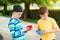 Friends on a walk with silicon bubble toys. Boys having fun outdoors. Modern antistress toy for children