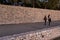 Friends walking through a pathway surrounded by rock walls in a park