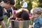 Friends watch pre-teen girl apple bobbing at backyard party