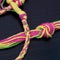 Friendship bracelet made with yellow, pink and green embroidery floss