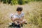 Friendship of a child with a dog. Happy boy holding a West Highland White Terrier puppy in his arms.