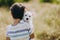 Friendship of a child with a dog. Happy boy holding a West Highland White Terrier puppy in his arms.