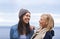 Friendship and laughter can brighten any day. Two happy young women smiling on the beach.