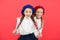 Friendship means support. Girls best friends on red background. Cute playful sisters schoolgirls having fun. Kids long