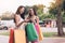 Friendship women standing at outlet mall and looking inside shopping bags paper