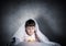 Frightened child with flashlight under blanket