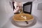 Frightened girl looking in microwave. Crumbs white bread on plate in oven