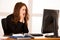 Frightened stressed woman working at her desk in the office, reading bad report.