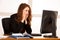 Frightened stressed woman working at her desk in the office, reading bad report.