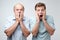 Frightened two men have scared expressions, look nervously, isolated over white background.