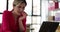 Frightened woman biting nails while working on laptop