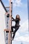 frightened woman, suffering from acrophobia, looking down while climbing stairs on rooftop.