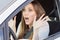 Frightened young car driver woman look straight