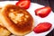Fritters on a plate with strawberries wooden background