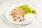 Frog saussages with lettuce, herbs and sauce on white background