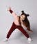 Frolic brunette kid girl in modern fashion pink brown sportwear is bending over with her arms outstretched