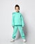 Frolic kid boy with stylish haircut in pastel modern green, mint color hoodie stands calm, quietly waiting, listening