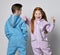 Frolic kids in blue and pink jumpsuits are standing next to each other, boy with his back to us and girl with her face