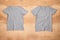 Front and back of grey melange empty T-shirt on wooden background