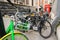 The front basket of a Lime electric assist rental bike parked with regular bicycles with a traditional red phone box in the