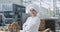 In front of the camera charismatic baker woman in a industrial kitchen smiling large and looking stray to the camera