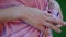 In front of the camera closeup details woman close her pink robe while she is outside at terrace in a windy day