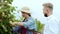In front of the camera countryside woman farmer in the vineyard collecting the grapes harvest while the businessman with