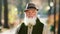 In front of the camera smiling charismatic old man with a perfect teeth in the middle of the park in a sunny autumn day