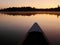 Front of canoe on peaceful Ox lake at sunrise. Minnesota, the Land of 10000 lakes, USA.