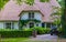 The front of a classical dutch home with driveway, luxurious house in the forest, Vintage cottage with a thatched roof