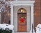 Front door with Christmas wreath on woodgrain door