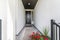 Front door corridor with white walls leading to a wooden door with window panel