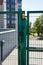 Front door of the courtyard. Metal Wire Fence.Green metal driveway entrance gates