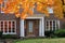 front door with maple tree in brilliant fall color