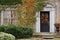 Front door of old brick house with fall wreath