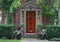 Front door of older brick house with shady garden