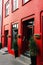 Front door with steps in reykjavik, iceland. House entrance with red door and pot plant decoration. Private property and real