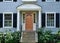 Front door of traditional two story suburban clapboard house