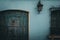 front door and window with safety bars in a blue painted small, old house in Guatemala