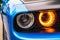 The front double headlight of a sports blue car. Orange headlight