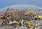Front end loader and excavators at landfill for disposal of construction waste. Excavator at mining quarry on rainbow background.